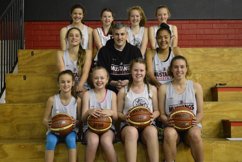 GOOD LUCK GIRLS: Members of the Maitland Mustangs under-14 women's team with their coach Mark Wawszkowicz. The girls take on the nation's best teams next week in Maitland. Picture: Michael Hartshorn
