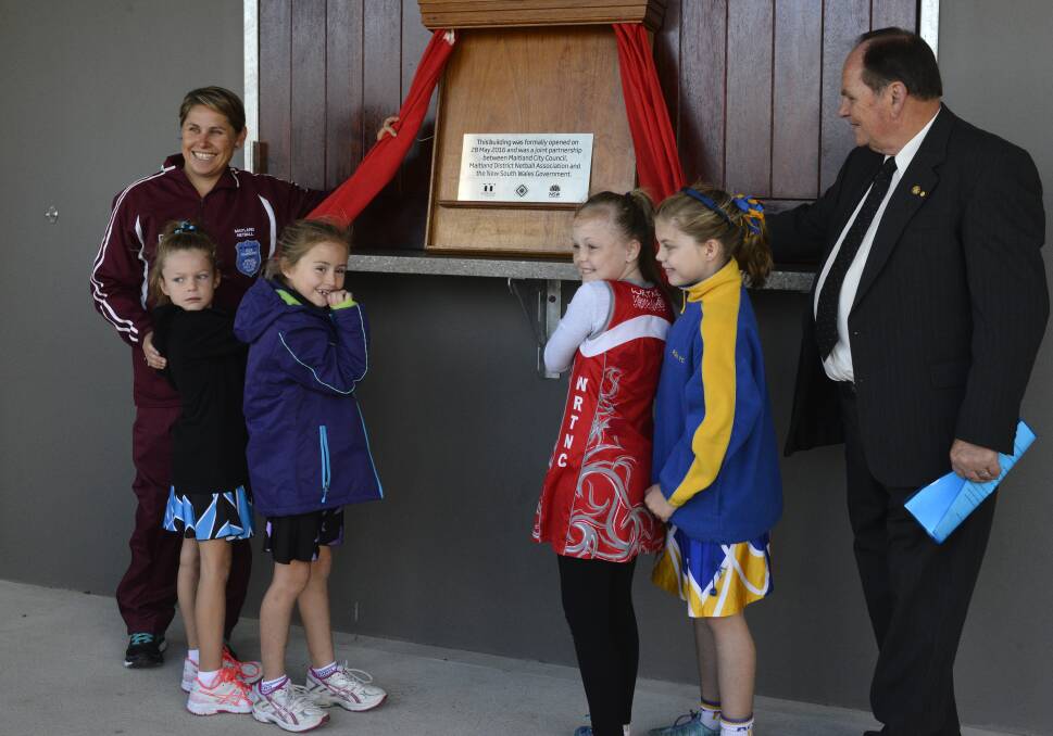 Maitland Netball Association president Kim Starkey and Maitland mayor Peter Blackmore receive help from some of Maitland netball's younger members to officially open the associations new headquarters. Picture: MICHAEL HARTSHORN