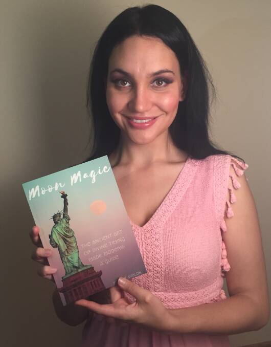 INSIGHT: Former Cessnock woman Kelsey Lucas with her newly-published book, Moon Magic - The Ancient Art of Divine Timing Made Modern: A Guide.