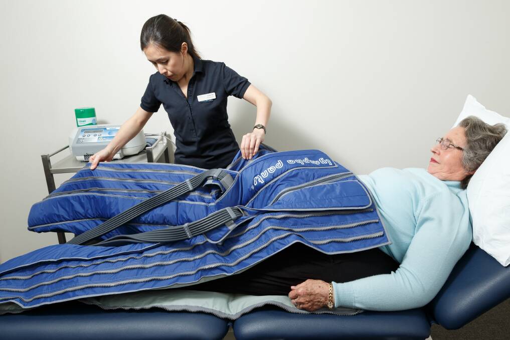 HELP: Senior physiotherapist Chia Yie Loh with patient Janice Bellamy in a pair of inflatable trousers which are used to lessen swelling. Picture: Max Mason-Hubers