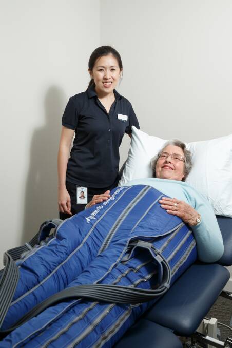 HELP: Senior physiotherapist Chia Yie Loh with patient Janice Bellamy in a pair of inflatable trousers which are used to lessen swelling. Picture: Max Mason-Hubers