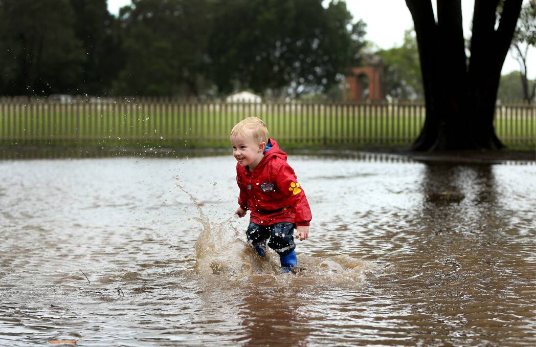 SPLASHDOWN: Jaxson Martin, 3, having a ball in the puddles at Maitland Park on Tuesday. Picture: Marina Neil.