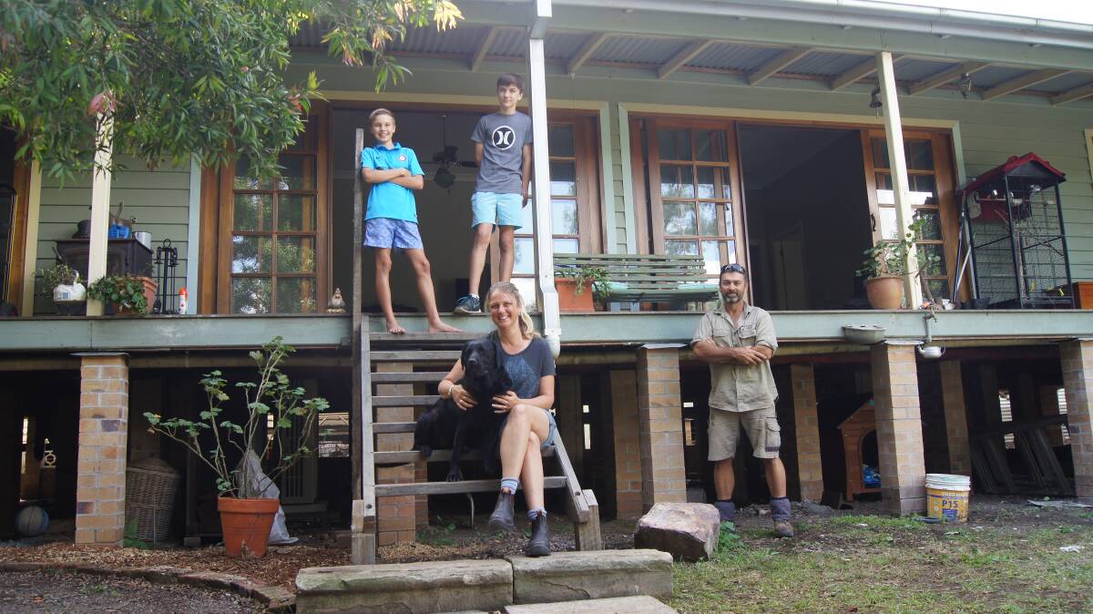 SURVIVORS: Jane and Anthony Lloyd-Jones with sons Tom, and Will and dog Vada. They have moved back in almost a year since the super storm damaged their home. Picture: BELINDA-JANE DAVIS