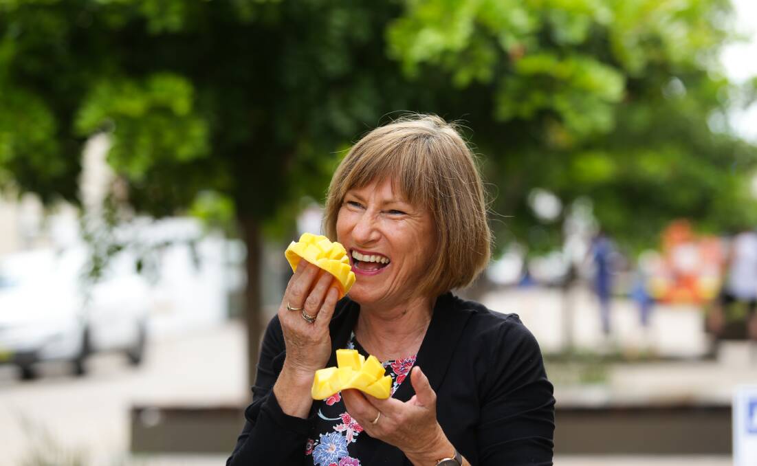 JUICY GOODNESS: Slow Food Hunter Valley vice president Helen Hughes with a Kensington Pride mango in The Levee. Picture: Jonathan Carroll. 