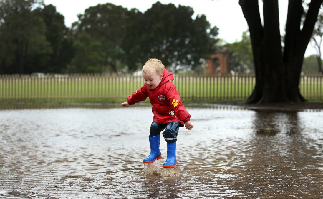 SPLASHDOWN: Jaxson Martin, 3, having a ball in the puddles at Maitland Park on Tuesday. Pictures: Marina Neil.