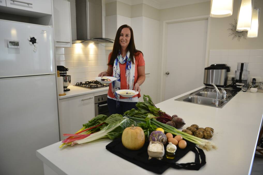 CREATIVITY: Ashtonfield mum Renah Nelson holds two of the dishes she made for the Eat Local Challenge. She is pictured with some homegrown produce and mystery bag ingredients. Picture: Belinda-Jane Davis