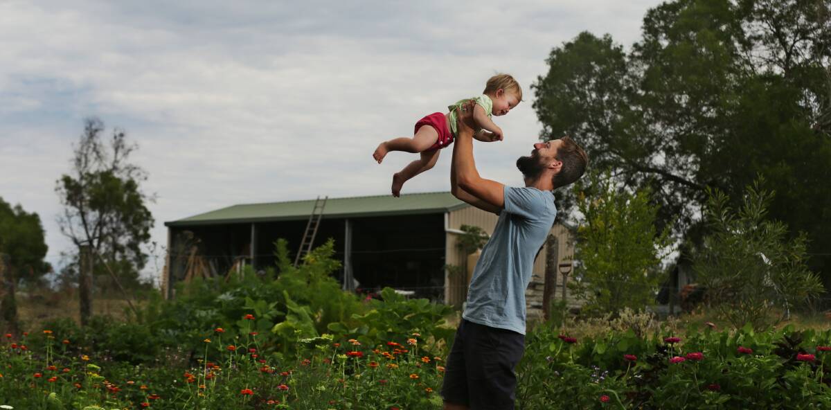 DESTINY: Novocastrian turned farmer Tom Christie with his daughter Evelyn standing among the flowers at his farm. Picture: Simone De Peak