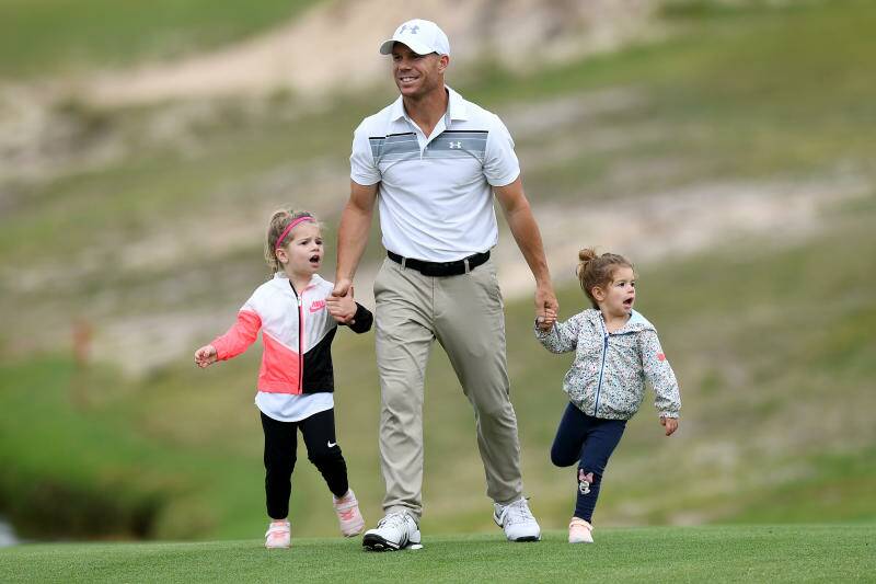 Cricketer David Warner walks with his daughters Ivy (left) and Indi on the 11th hole during the Pro-Am round of the Australian Open Golf Tournament in November.