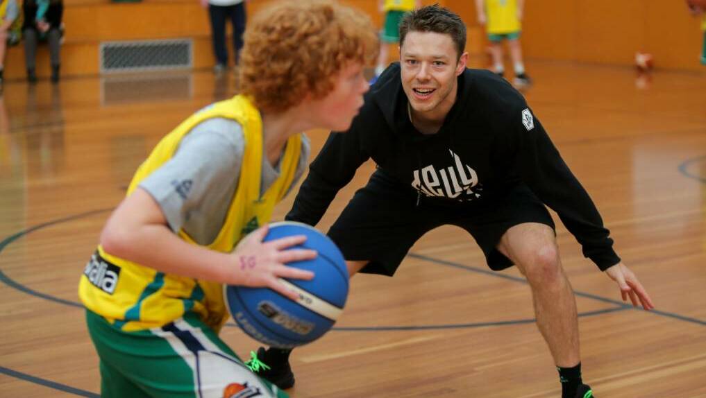Warrnambool Seahawks' under player Will Rantall, 10, looks for an option as he takes on NBA star Matthew Dellavedova. Picture: Rob Gunstone