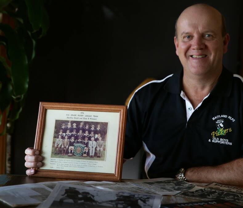 HISTORY WAS MADE: Geoff McMahon with a photograph of the 1976 Maitland Boys High School winning Buckley Shield side. Picture: MARINA NEIL.