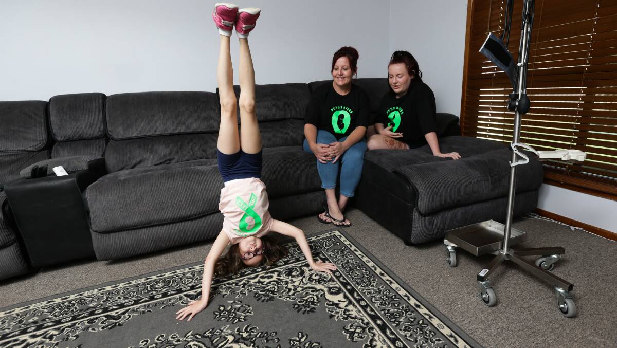 Bubbly: Lucy with her mum Leigh Kenyon, and big sister Lily. Lucy hasn't let her condition dull her love of acrobatics. 