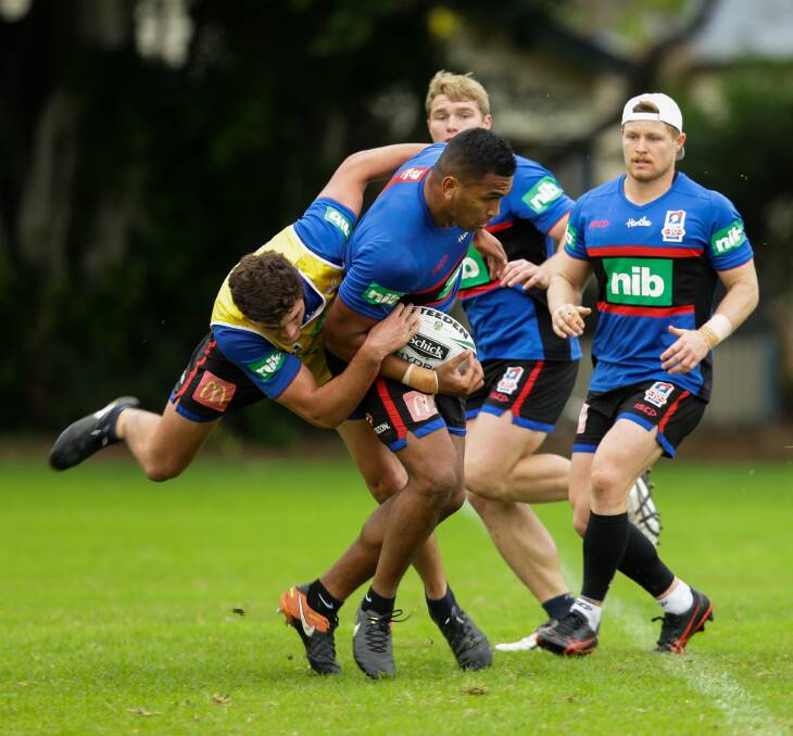 HARD YARDS: Knights prop Daniel Saifiti breaks through a tackle by Sam Stone at training. Picture: Jonathan Carroll