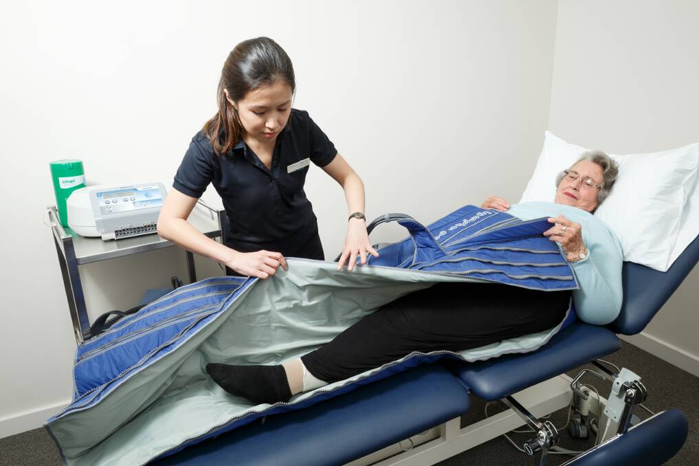Options: Chia Yie Loh treats Janice Bellamy at Maitland Private Hospital with inflatable trousers used to reduce swelling. Picture: Max Mason-Hubers.