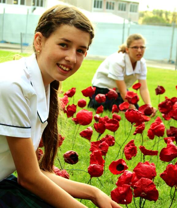 THOUGH POPPIES GROW: Students from St Joseph's Lochinvar in the exhibition of 1000 poppies that honour fallen heroes and art teacher Fiona Donoghue, who passed away last year. Picture: Supplied.