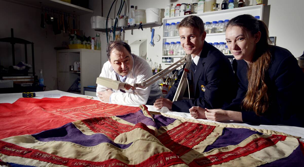 HONOUR: Restorer Duncan Harty with Maitland High School captains Mark Winter and Daynah Elford with the flag last year. Picture: STUART SCOTT