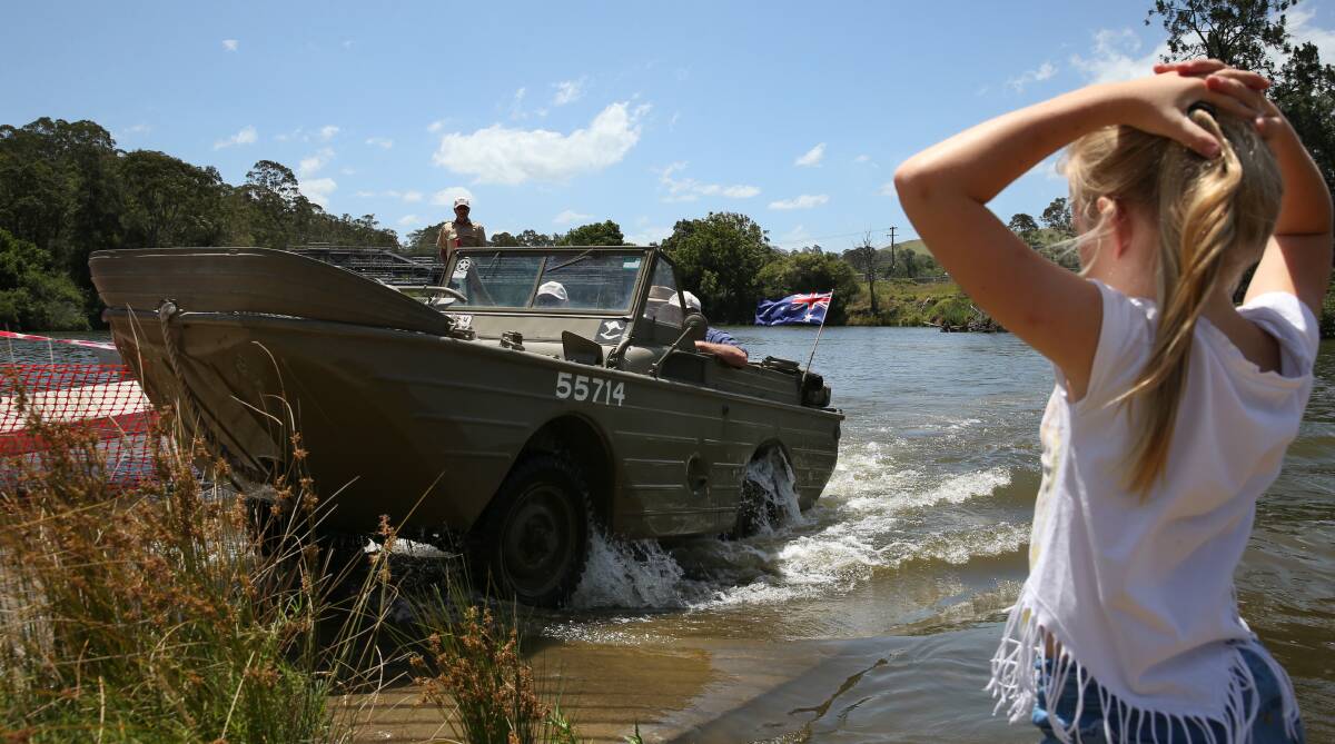 SPLASH: An amphibious vehicle pulls itself out of the Williams River near Clarence Town on the weekend at the gathering. Picture: Max Mason-Hubers