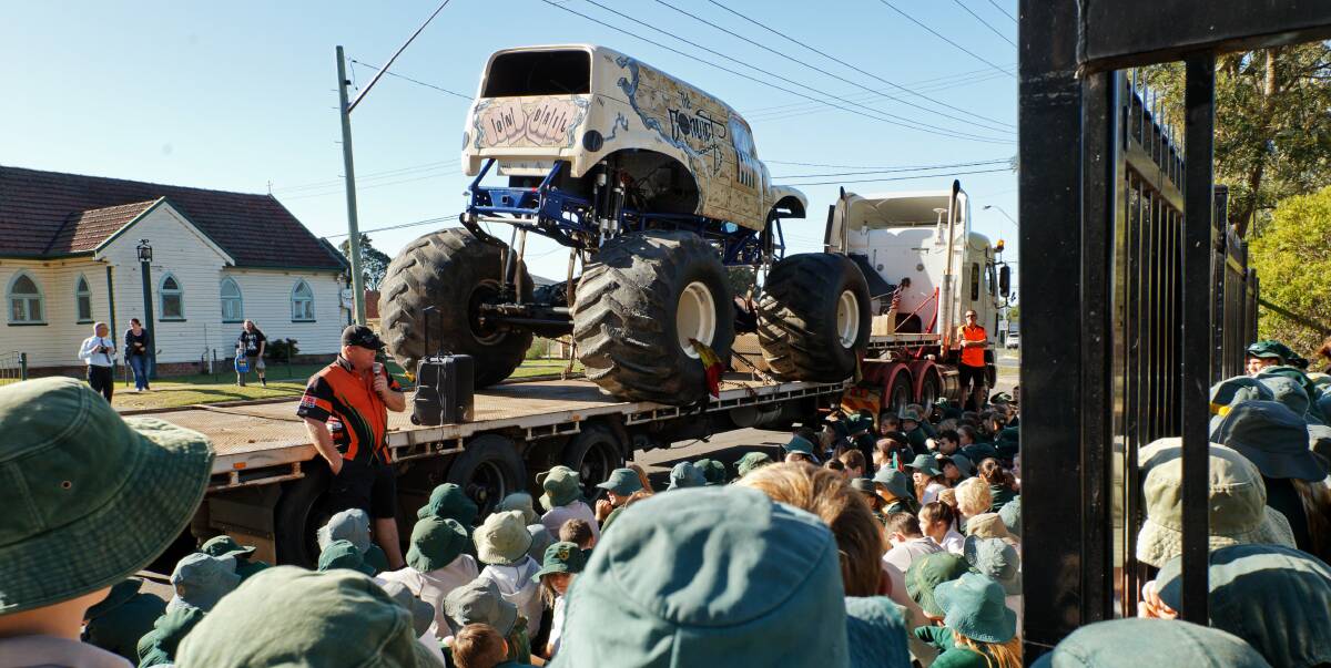MONSTER: Thornton Public School students listening to monster truck driver and promoter Rusty Bell in front of "Convict", parked in front of the school. Picture: MAX MASON-HUBERS