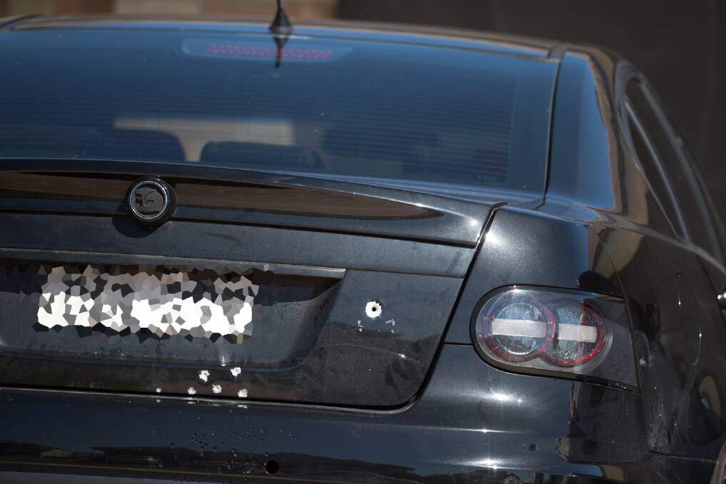 SHOT: A car parked in the driveway of a Conder Crescent home peppered with bullet holes. Pictures: Fairfax Media