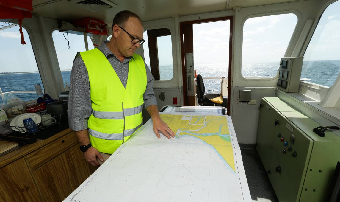 PLANNING: Port of Newcastle's Keith Wilks examines a chart in the bridge.