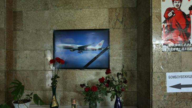 Flowers and a candle sit underneath a poster of a Malaysian plane on the wall in the Donetsk Administration building in the self-proclaimed Donetsk People's Republic.  Photo: Kate Geraghty