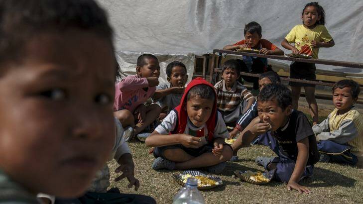 Earthquake survivors eat breakfast in a makeshift shelter in Sankhu, on the outskirts of Kathmandu, Nepal, on Tuesday. Photo: Athit Perawongmetha