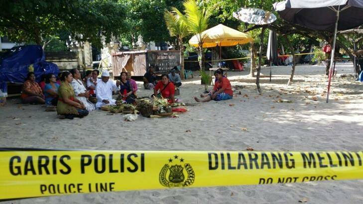 Family of the slain police officer hold a Ngulapin cleansing ceremony on Kuta beach. Photo: Supplied