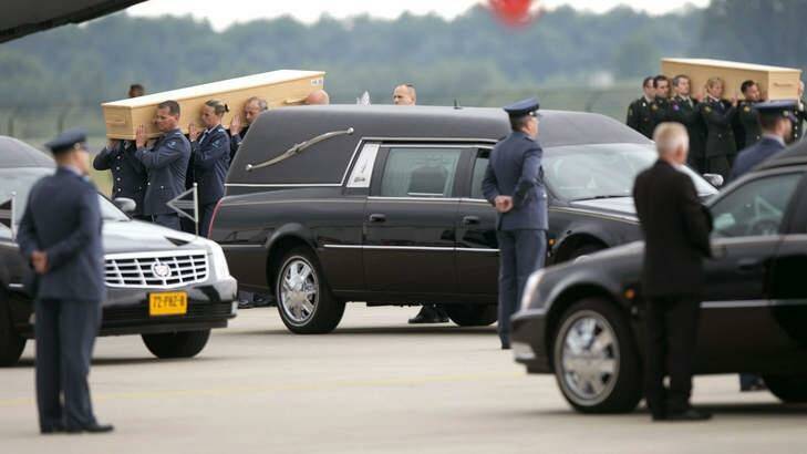  Dutch military personnel carry coffins containing the remains of the victims of the MH17 plane crash to a waiting hearse at the airbase in Eindhoven.