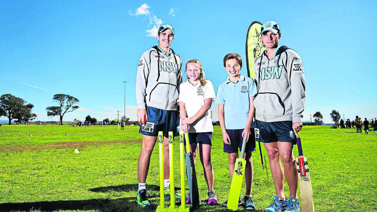  NSW cricketers Sean Abbott (left) and Patrick Pisel with Morpeth Public School students Molly Worthington and Thomas Forbes.