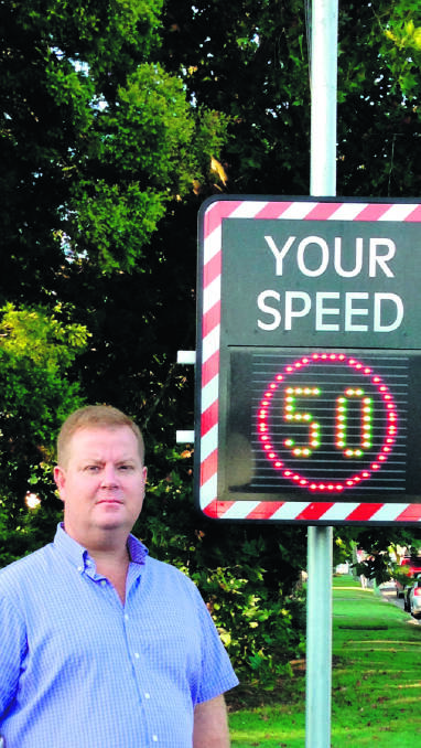 Philip Penfold with one of the solar-powered speed limit signs.