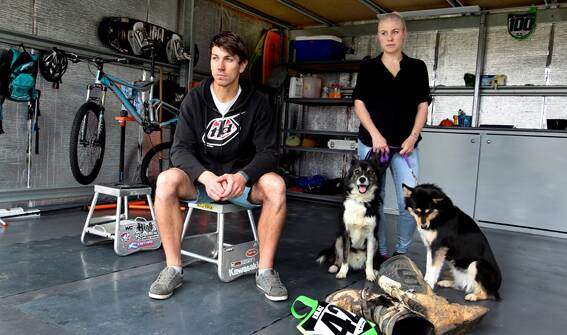 ANGRY:  Ricky Kalisz with his partner Sarah Bevan and dogs Shyla and Kobi in their empty garage where they had three trail bikes worth $30,000 stolen. 