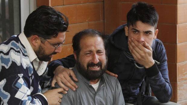 Relatives of a student, who was injured during an attack by Taliban gunmen on the Army Public School, comfort each other outside Lady Reading Hospital in Peshawar. Photo: Reuters