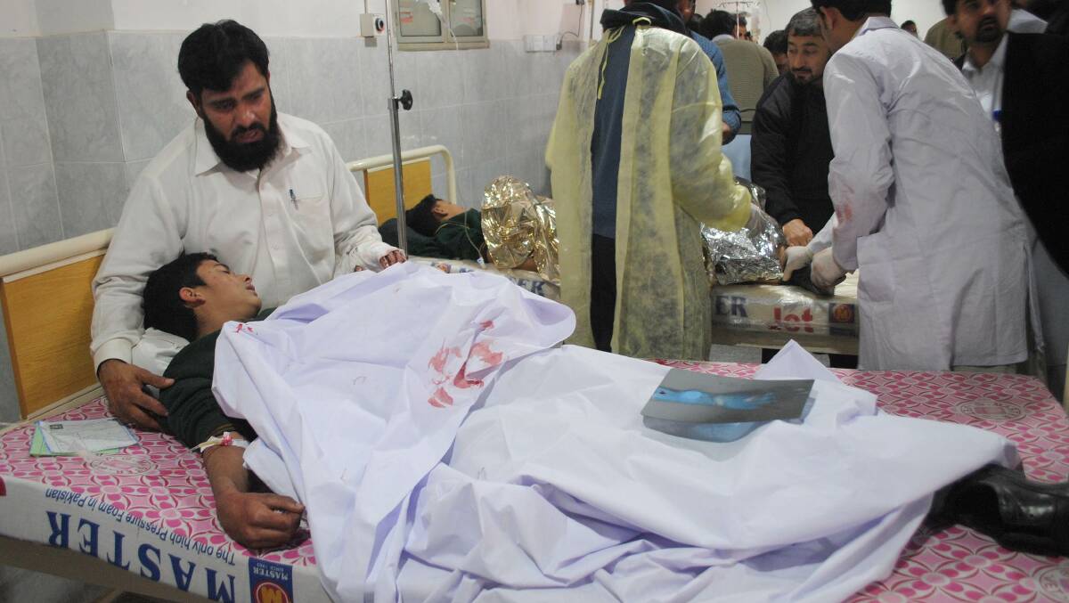 A man comforts his son, who was injured during an attack by Taliban gunmen on the Army Public School, at Lady Reading Hospital in Peshawar, December 16, 2014. This is not the boy Salman who played dead to avoid the gunmen. Photo: Reuters.