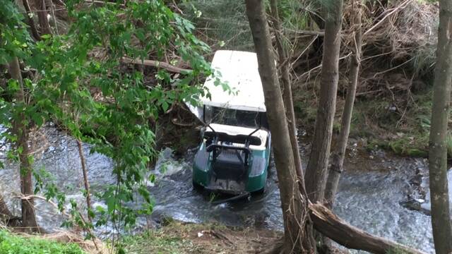 ACCIDENT: The golf cart remains in the creek at the scene of the accident. 