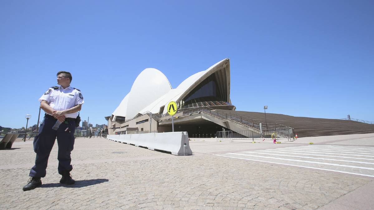 EVACUATED:  A police officer stands alone in front of the Opera House which was evacuated.