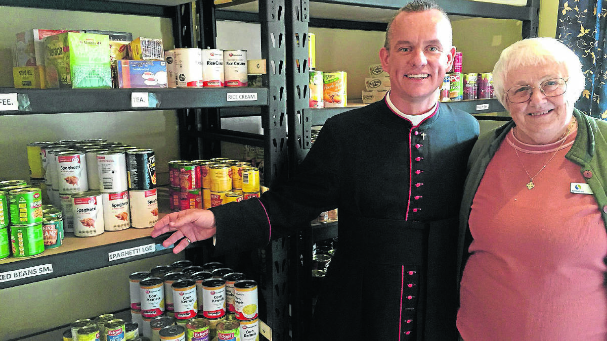 HELPING HAND:  Father David Battrick of St Peter’s Church East Maitland with emergency relief co-ordinator Judy Cordwell. Picture by ALAN HARDIE 