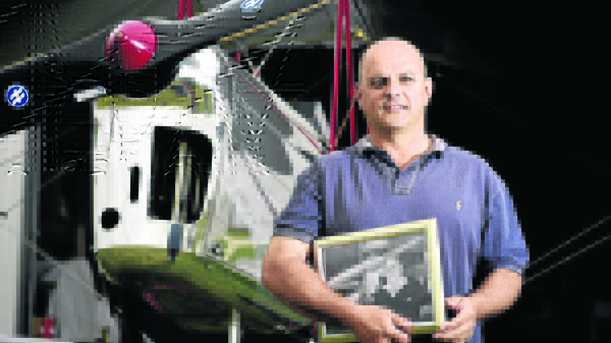 JOINING DAD FOR A FINAL FLIGHT:  Tiger Moth pilot  David Fletcher, holding a picture of his father, a popular member of the Luskintyre Airfield family.   	
	Picture by PERRY DUFFIN