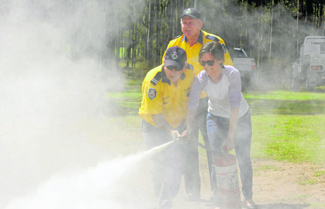 BLOWING SMOKE:  Volunteer firefighters Bob Shorten and Ian Powell show Largs resident Alison Hutton how to use an extinguisher. Picture by STUART SCOTT