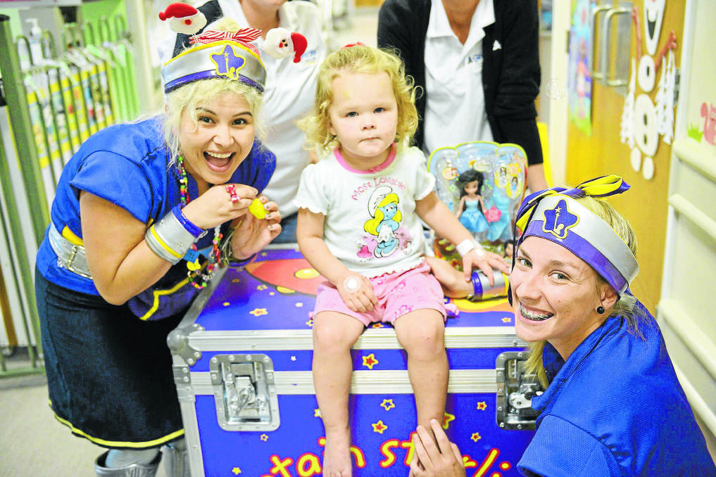 SURPRISE VISITORS: Two-year-old Khole Hassett of Singleton with members of the Captain Starlight team who dropped in for a visit.                                                                      Picture by STUART SCOTT