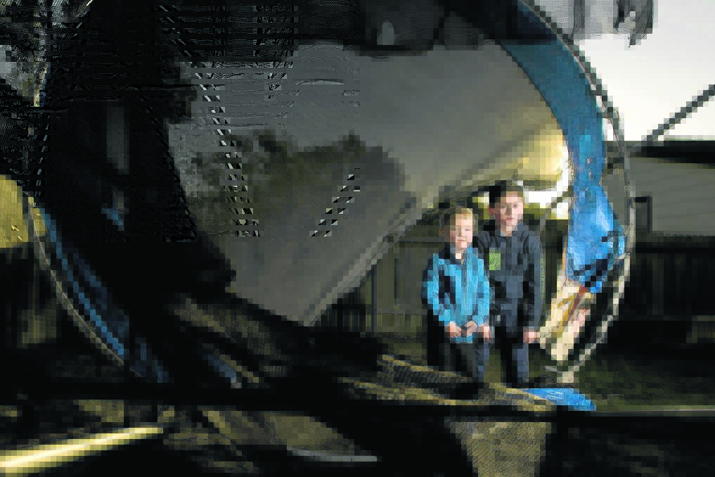 SHATTERED:  Brayth and Zane Bryson, and the remains of their much-loved trampoline.   	Picture by PERRY DUFFIN