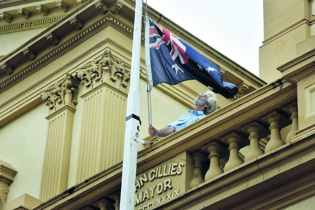 VALE GOUGH WHITLAM: Bill Hadden lowers the flag at Maitland Town Hall to half mast as the city joins a nation in mourning former prime minister Gough Whitlam.