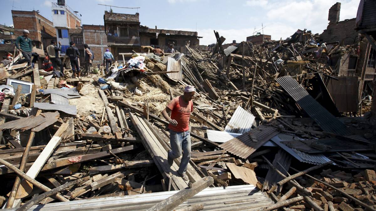 DEVASTATION:  A man walks in the rubble of collapsed houses in Bhaktapur.