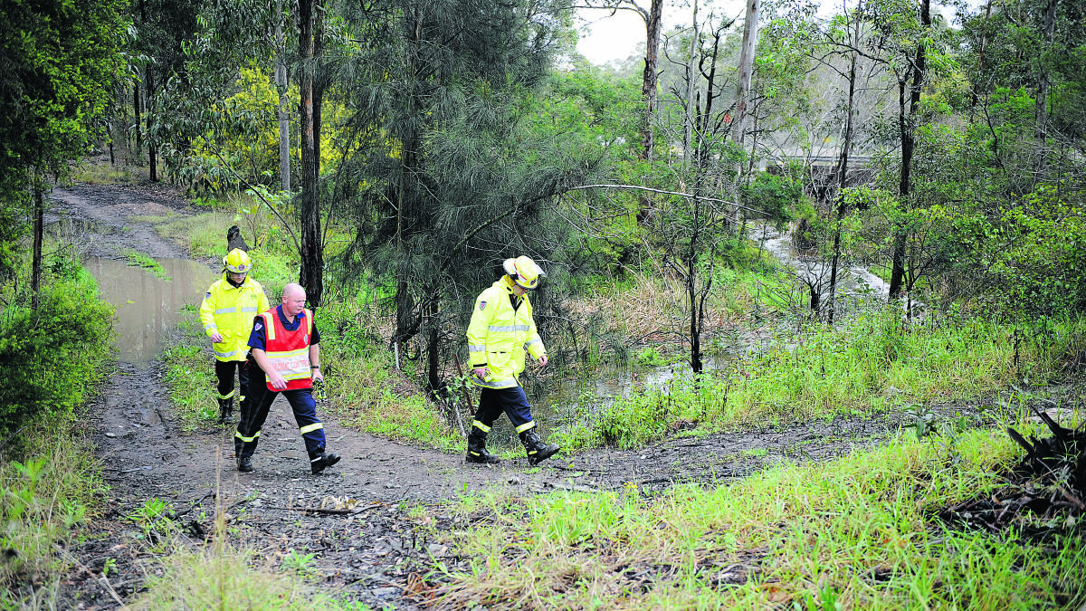 CREEK CONTAMINATED: Firies inspect the creek where a toxic substance was reported by a member of the public.