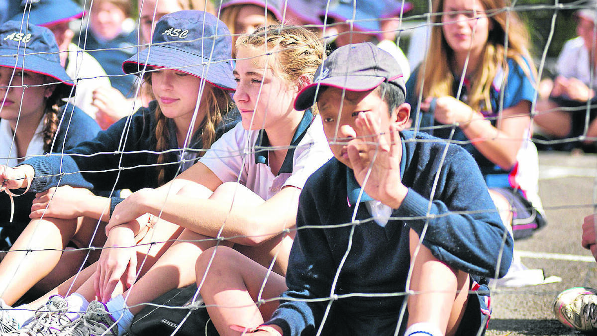 JUST LIKE A REFUGEE:  Year 7 students Paris Galloway, Mia Barclay and Dominic Cai spend time behind wire.