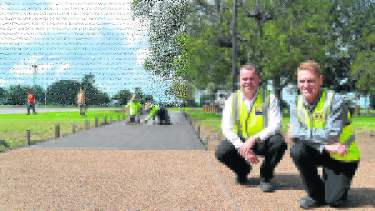 FINAL TOUCH:  Ashley Kavanagh and Glen Thorley inspect final work on the Maitland Park cycleway. Picture by JESSICA BROWN