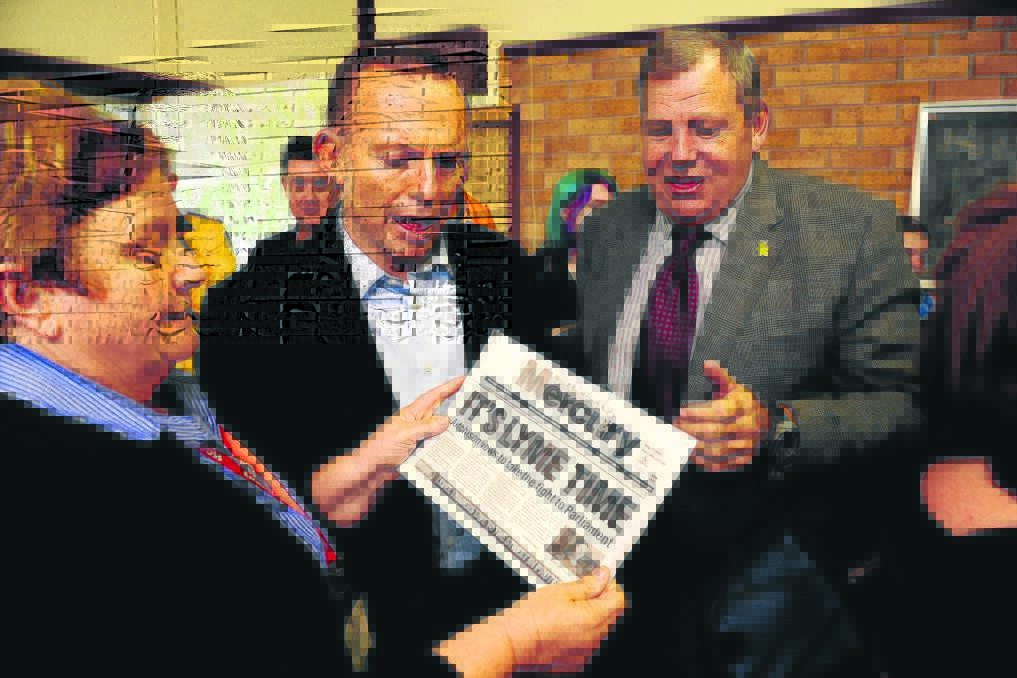 GENTLE PROD:  Lurline Trustum presents Prime Minister Tony Abbott with a copy of the Mercury’s recent front page article onthe push for the ­government to reconsider its decision not to acknowledge Lyme disease in Australia.	Picture by PERRY DUFFIN
