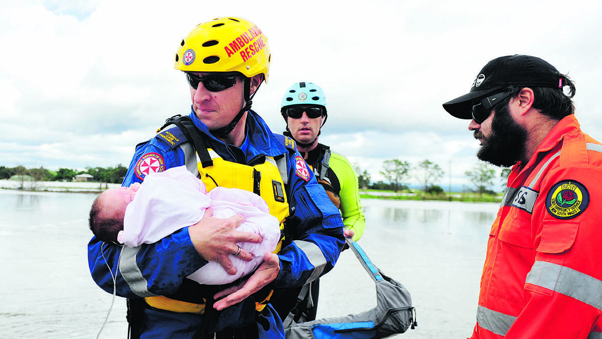 IN SAFE HANDS: Maitland paramedic Cameron Powell with the baby girl yesterday.  	Picture by CATH BOWEN