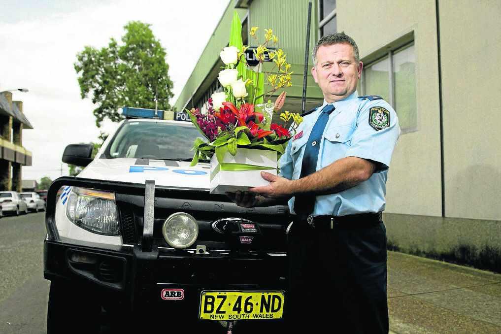 THANK YOU:  Detective Inspector John Zdrilic with a floral tribute sent to Maitland police as a thank you from a community group.	Picture by PERRY DUFFIN 