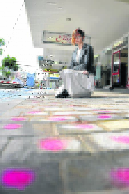 SEEING PINK: Ashleigh McIntyre a retail assistant, with some of the pink pavers that need work.  	Picture by PERRY DUFFIN