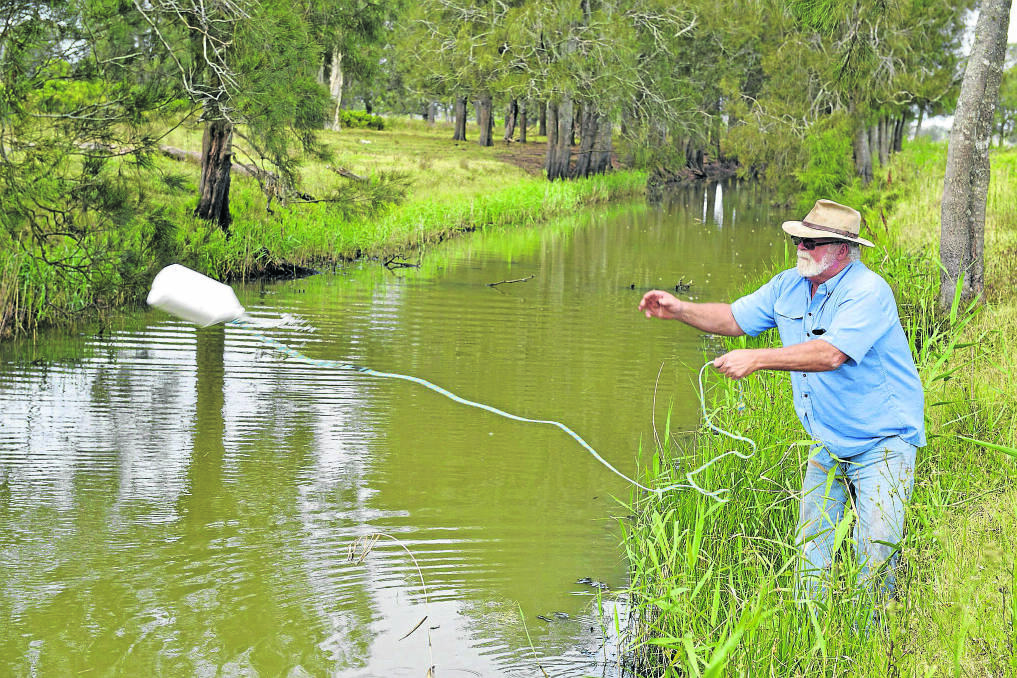 TESTS:  Millers Forest farmer Bill Munton casts out a bottle to take water samples in the Hunter River near his property. 	Pictures by STUART SCOTT