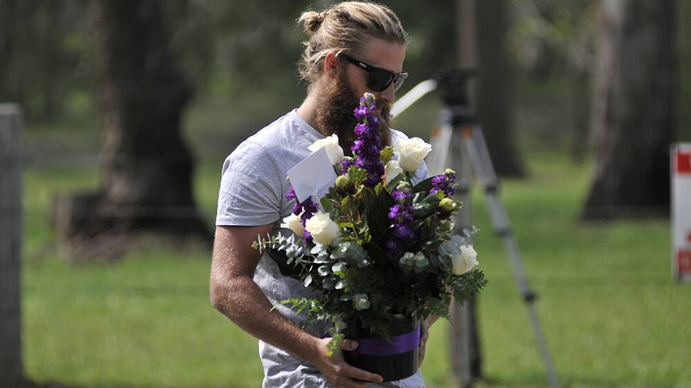 A man lays a floral tribute to the miners who died in the Austar coal mine collapse last night.